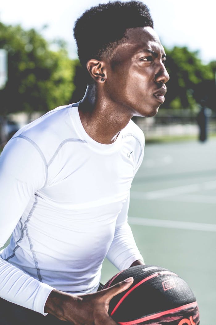 Intense moment of a basketball player outdoors, capturing focus and determination.